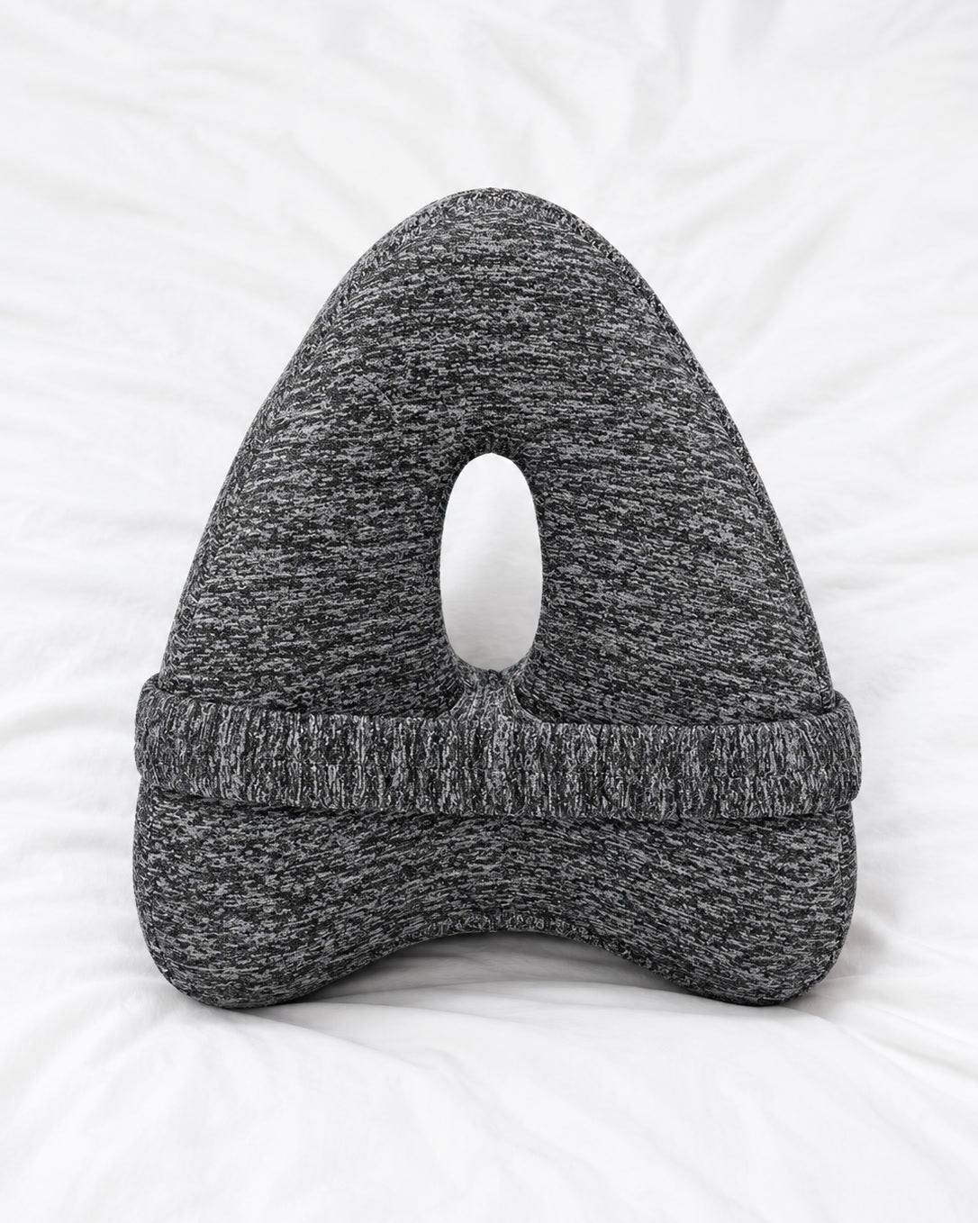 Snuggi knee pillow on a bed