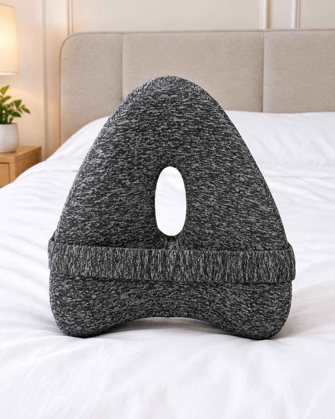 Snuggi knee pillow on a made bed